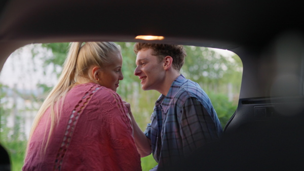 A young couple in love camping together in car, enjoying holiday time, vertical footage.