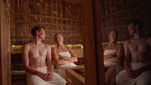 A young couple in love enjoying together time in Finnish sauna.