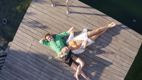 A top view of young couple lying together in terrace during summer day.