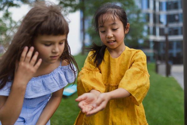 Happy friends playing and talking together in s city park, during summer day.