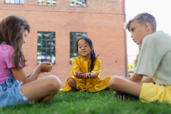 Happy kids playing and talking together in s city park, during summer day.