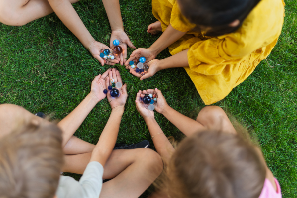 Top view of kids playing and talking together in s city park, during summer day.