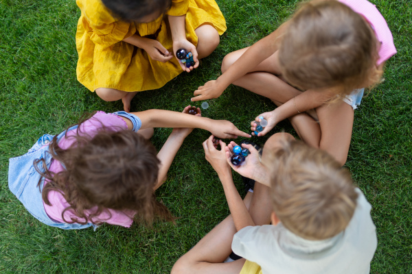 Happy kids playing and talking together in s city park, during summer day. Top view.