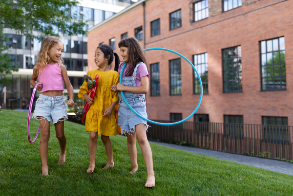 Happy kids playing and talking together in s city park, during summer day.