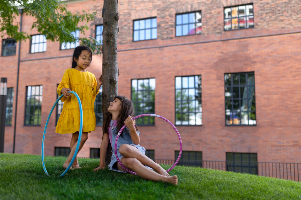 Happy friends playing and talking together in s city park, during summer day.