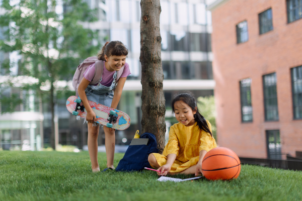 Happy kids playing and talking together in s city park, during summer day.