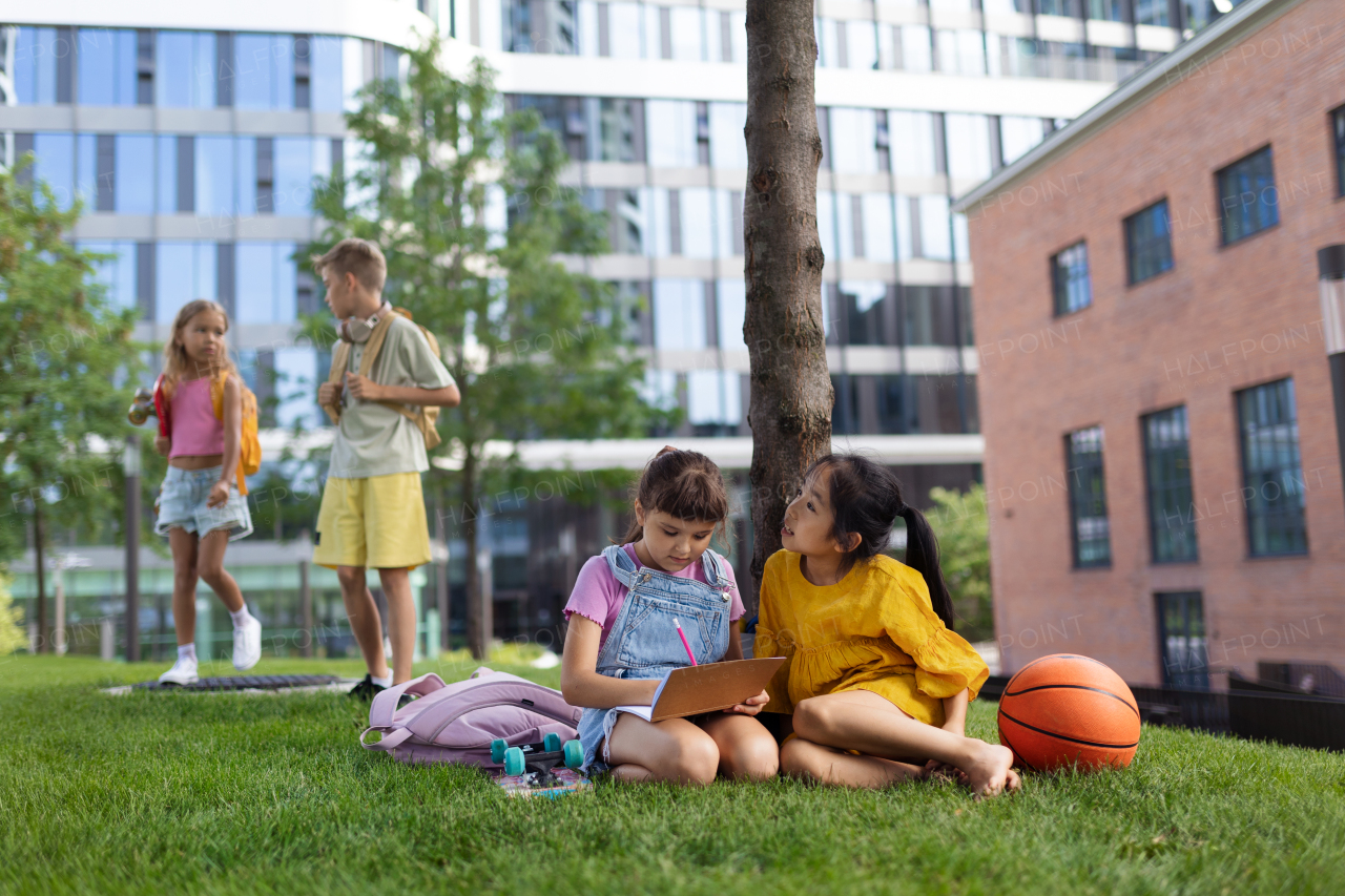 Happy kids playing and talking together in s city park, during summer day.