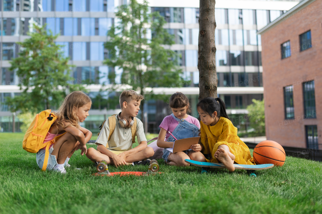 Happy kids playing and talking together in s city park, during summer day.