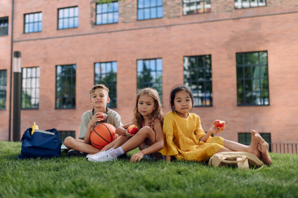 Happy kids playing and talking together in s city park, during summer day.