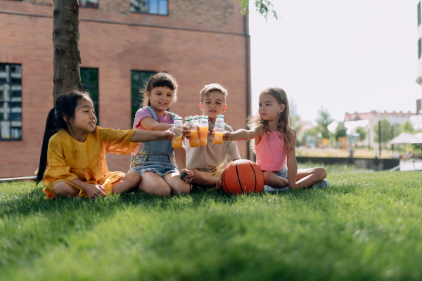 Happy kids playing and talking together in s city park, during summer day.