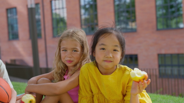 Happy kids playing and talking together in s city park, during summer day, looking at camera.