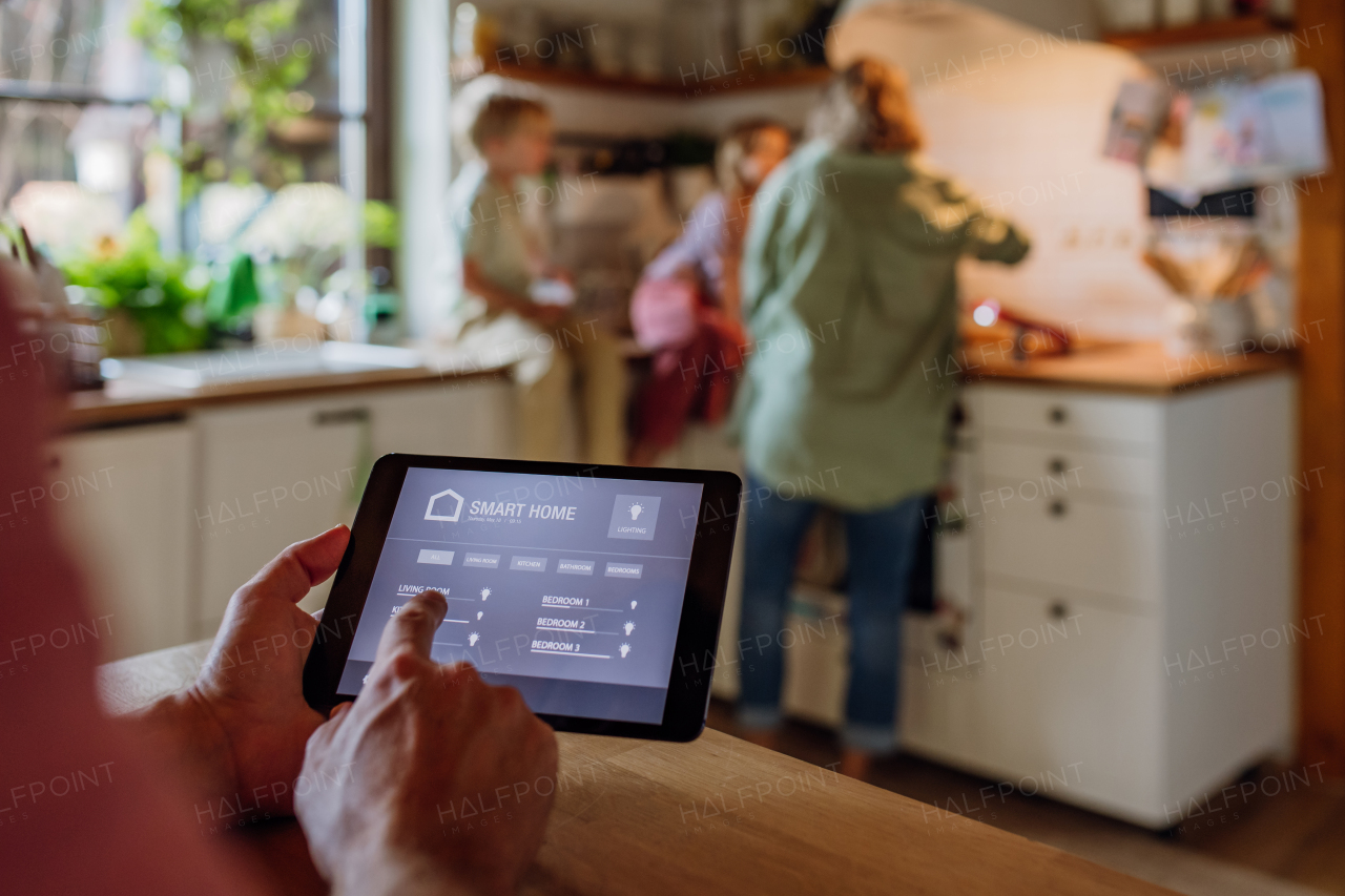 Father using smart thermostat, adjusting or lowering heating temperatures at home. Concept of sustainable, efficient, and smart technology in home heating and thermostats.