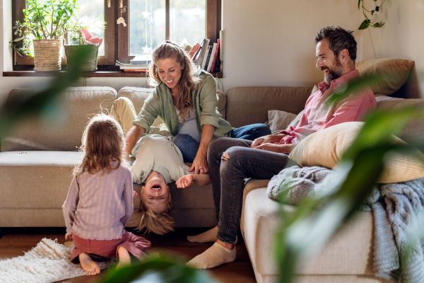 Portrait of young family at home. Pregnant mother with her children and husband in the living room.