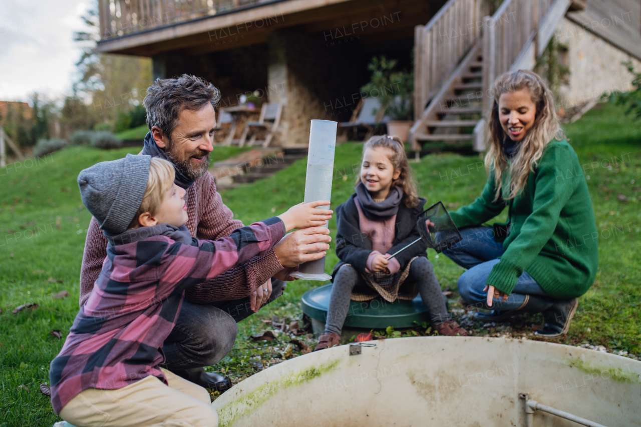 The family checks the water quality in the home wastewater or sewage treatment system. Concept of sustainable family living.