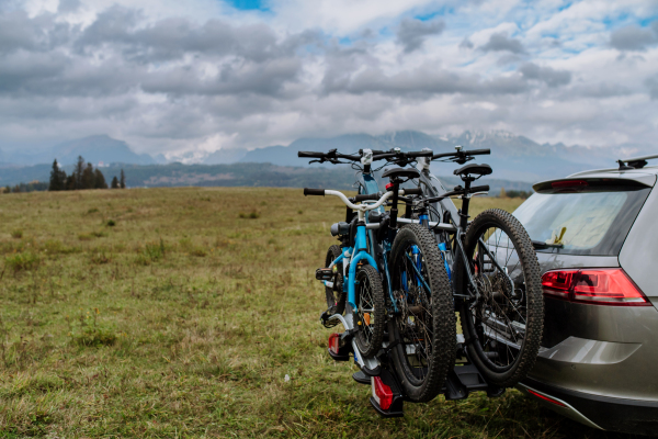 Car with bike racks and bicycles at an autumn meadow.