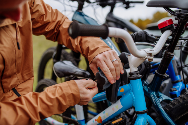 Close-up of putting bicycles on a car rack.