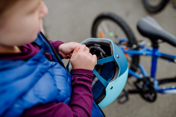 Top view of little boy holding a helmet, preparing for bicycling.