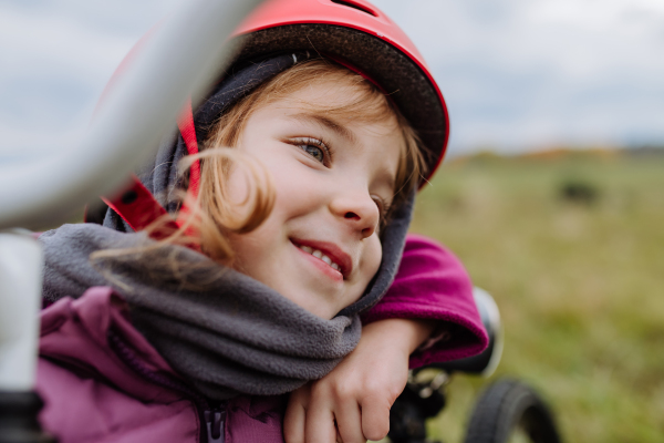 Portrait of happy little girl with a helmet on bicycle.