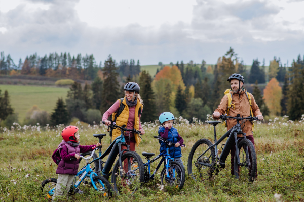 Young family with little children at bicycles, in the middle of autumn nature.Concept of healthy lifestyle.