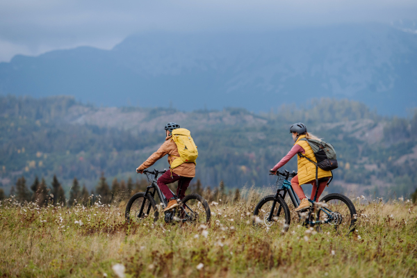 Happy couple at bicycles, in the middle of autumn nature.Concept of a healthy lifestyle, rear view.