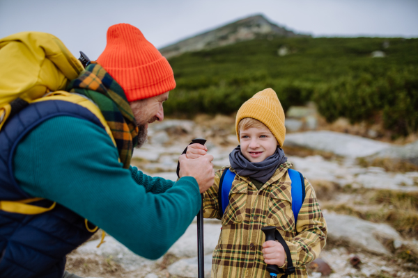 Father with his little son hiking in the mountains together.