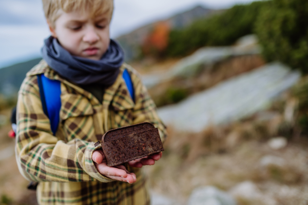 Little boy with a rusted trash in the middle of nature, concept of nature protection.