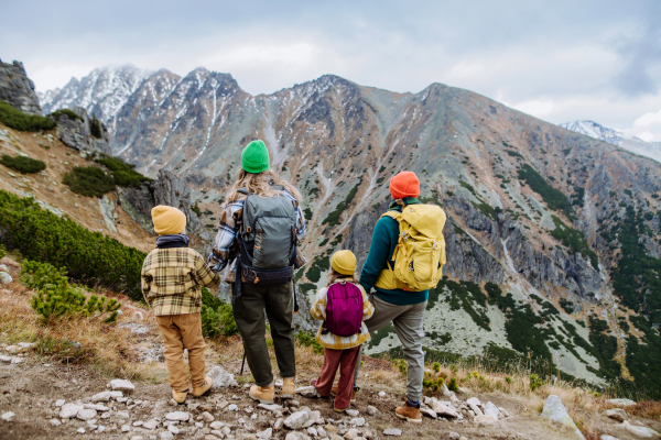 Rear view of family with little children at autumn hike in mountains. Concept of healthy lifestyle.