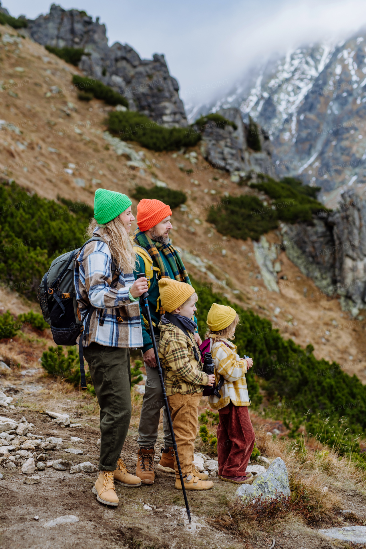 Side view of family with little children at autumn hike in mountains. Concept of healthy lifestyle.