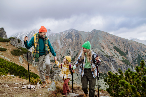 Happy family hiking together in an autumn mountains.