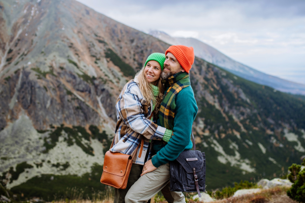 Young happy couple at a mountain hike, hugging each other.