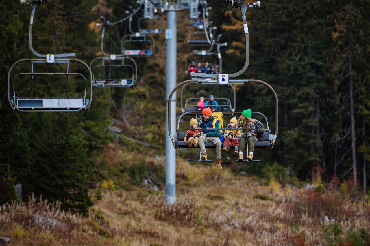 Family sitting inside of cable car and enjoying the view. Mountains with open cable cars lift during the tourist season,