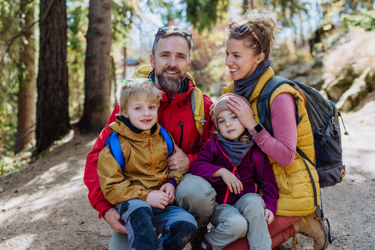 Happy young family with little children, resting near a lake in mountains.