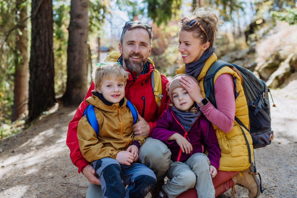 Happy young family with little children, resting near a lake in mountains.