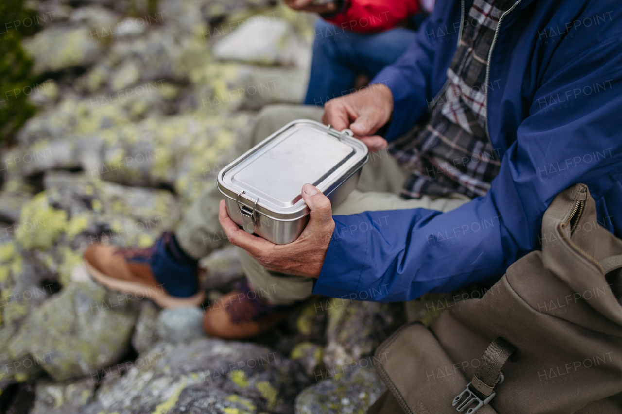 Close up of snack in lunchbox during hike. Couple of turists having healthy snack, to get energy .