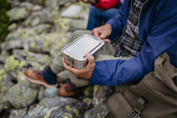 Close up of snack in lunchbox during hike. Couple of turists having healthy snack, to get energy .