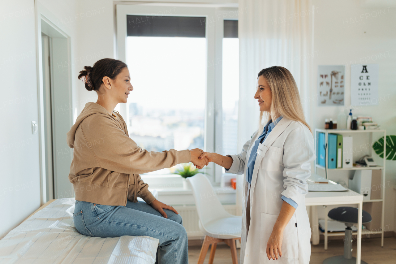 Teenage patient arriving at appointment with the doctor, shaking hands with female pediatrician, physician. Teen girl have consultation, first visit with gynecologist. Concept of preventive health care for adolescents.