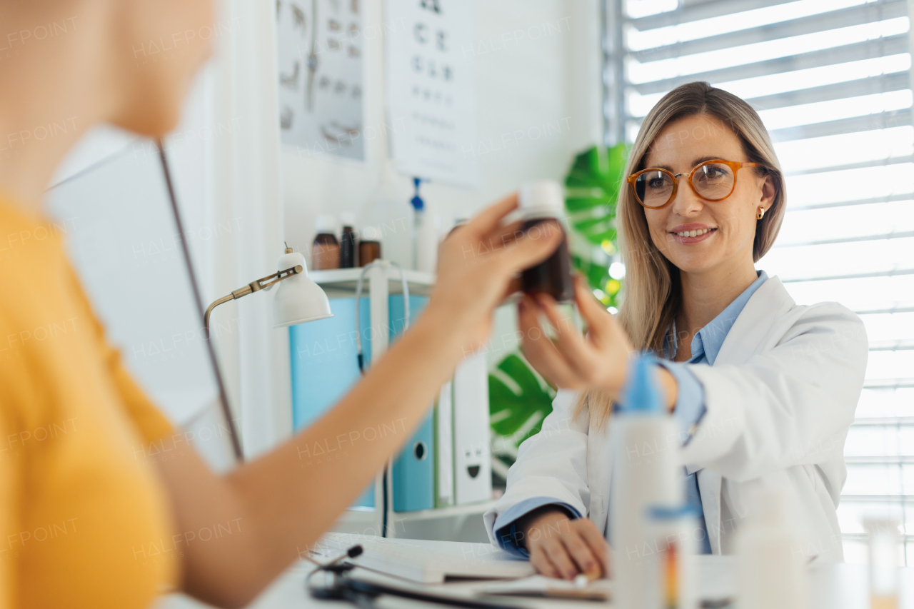 Teenage girl consulting taking vitamins and supplements with paediatrician. Doctor prescribing medication to ill teenage girl. Concept of preventive health care for adolescents.