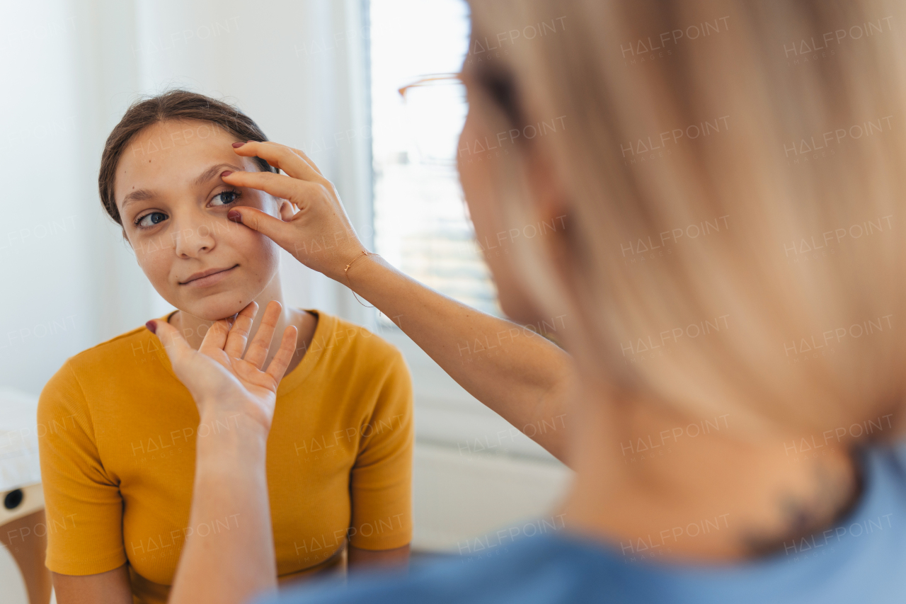 A pediatrician examining eyes of a teenage patient. Ophthalmologist treating an eye infection, allergy, or inflammation in ophthalmic clinic