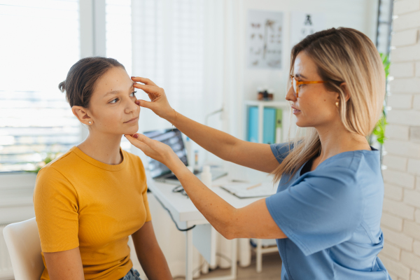 A pediatrician examining eyes of a teenage patient. Ophthalmologist treating an eye infection, allergy, or inflammation in ophthalmic clinic