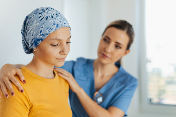 Teenage oncology patient talking with the doctor. Oncologist treating teen girl with cancer and provide emotional support, helping her with anxiety and depression.