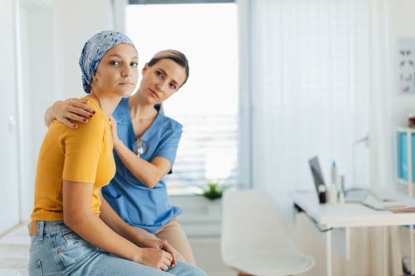 Teenage oncology patient talking with the doctor. Oncologist treating teen girl with cancer and provide emotional support, helping her with anxiety and depression.