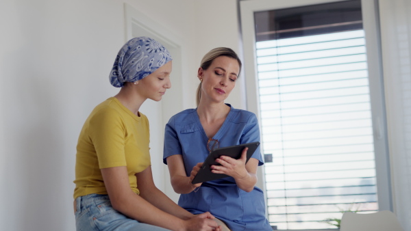 Teenage oncology patient talking with the doctor. Oncologist treating teen girl with cancer and provide emotional support, helping her with anxiety and depression.