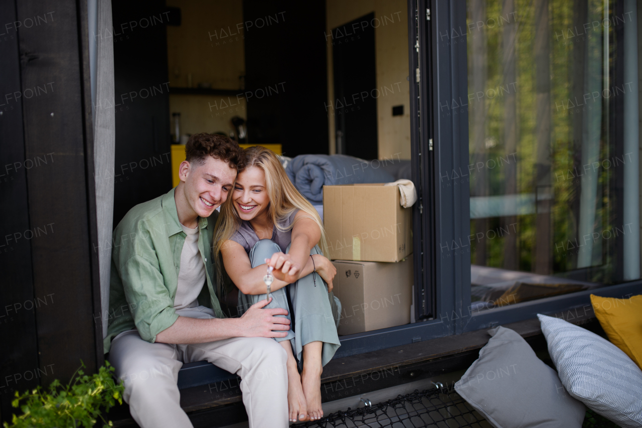 A cheerful young couple in their new apartment. Conception of moving.