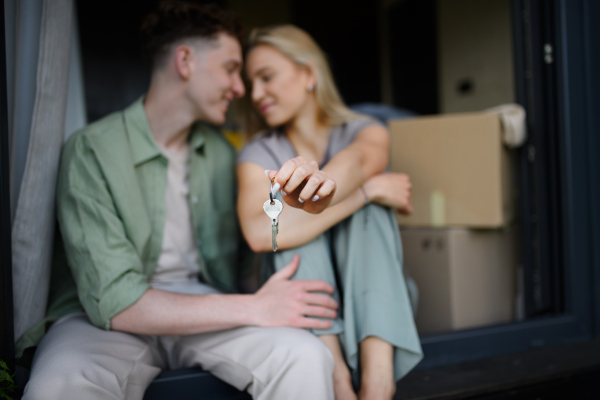 A cheerful young couple in their new apartment. Conception of moving.