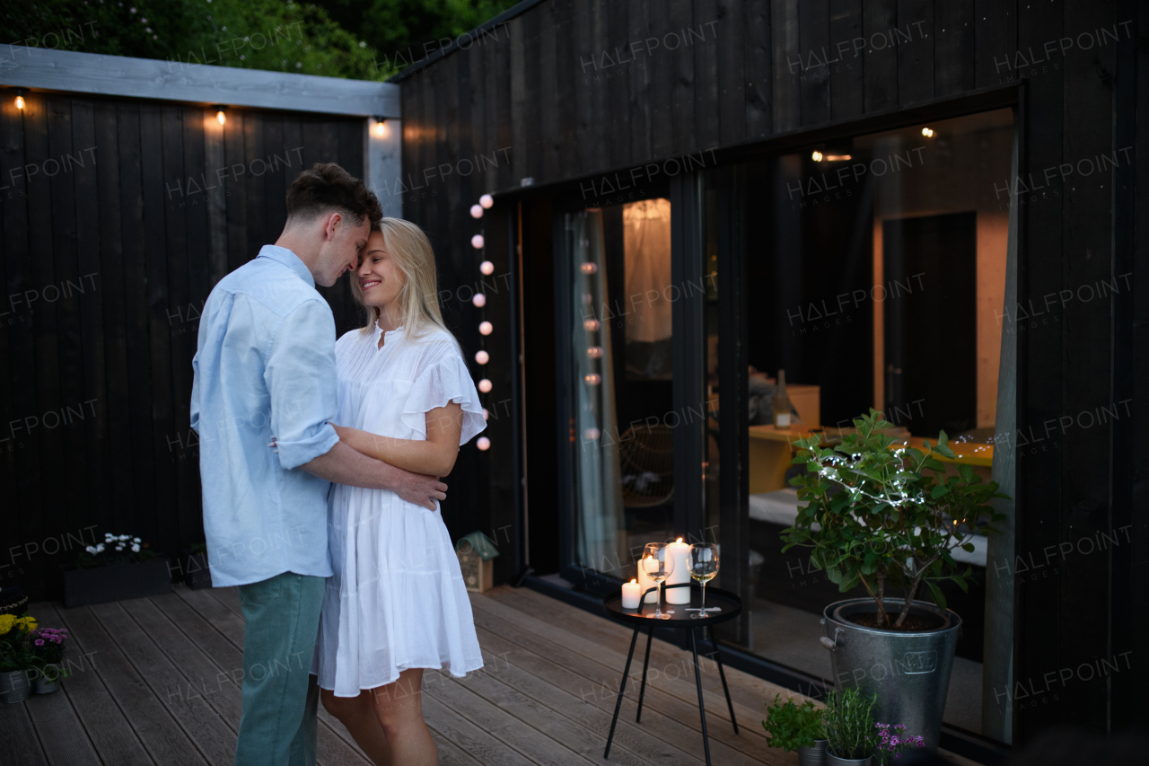 A young couple dancing outdoors, weekend away in tiny house in countryside, travel and holiday concept.