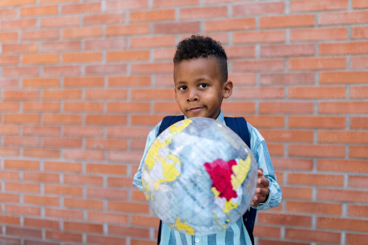 Multiracial boy playing outdoor with a beach ball.