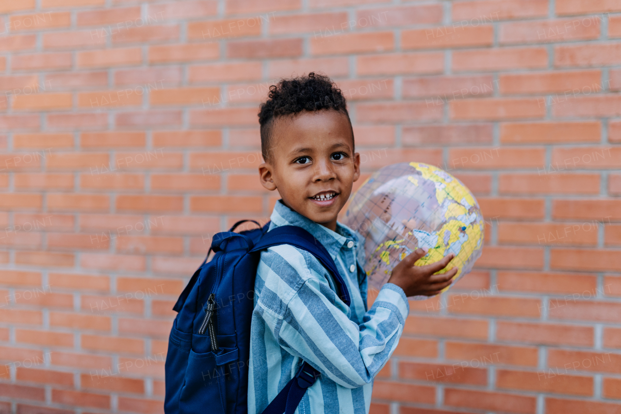 Multiracial boy playing outdoor with a beach ball.