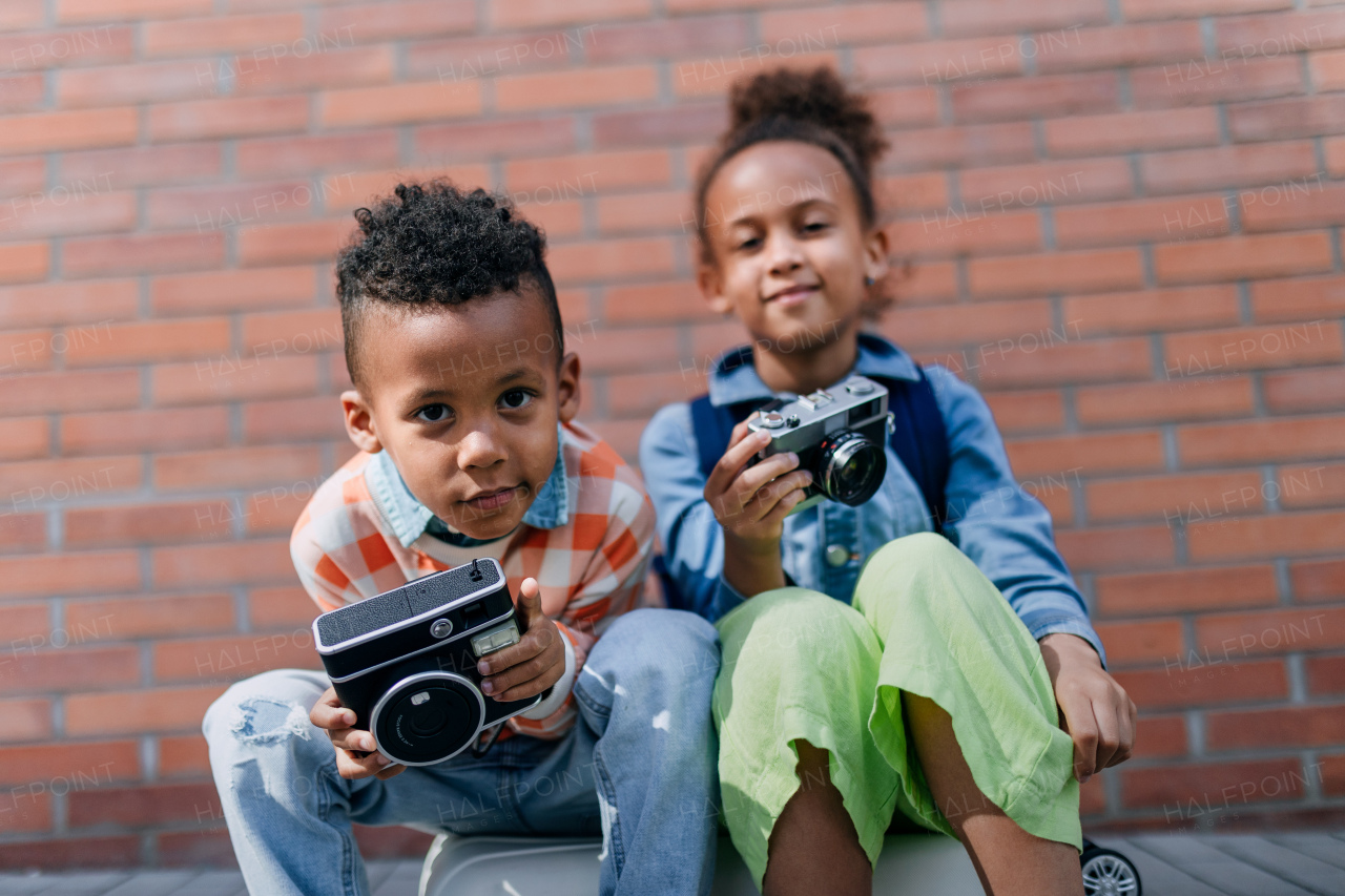 Multiracial siblings taking photos outdoor, enjoying holiday.