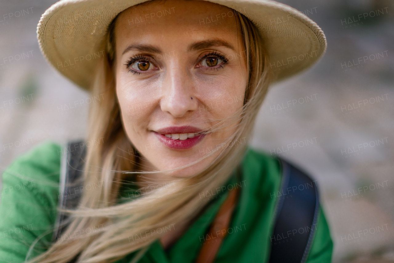 Portrait of a young woman traveler, sitting, resting, smiling and looking at camera.