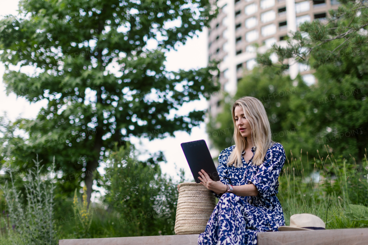 Mature woman sitting in a park bench, enjoying time for herself.